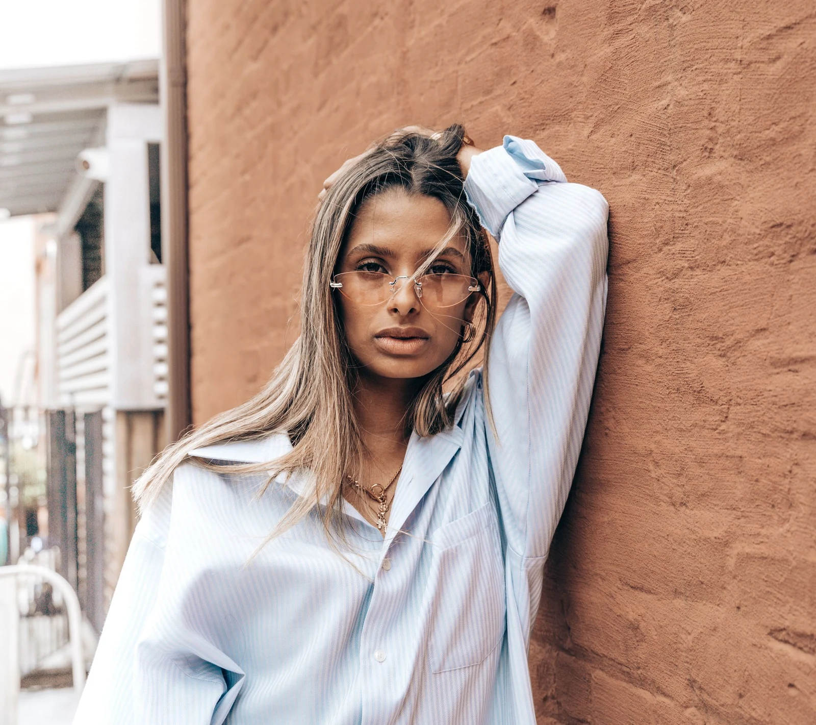 Femme portant une monture transparente, photographiée dans la rue.